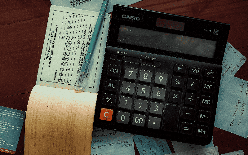Talão, caneta e calculadora representando a nota fiscal avulsa
